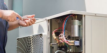 Technician Hands Using A Screwdriver Fixing Air Conditioner