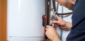 Worker Repairing An Electric Water Heater