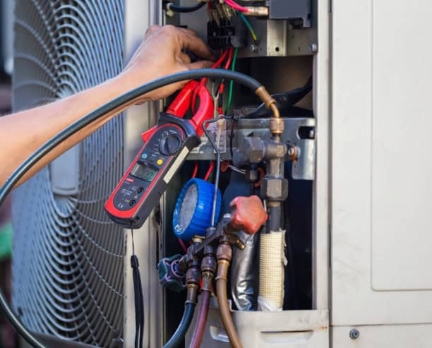 Tools hooked to the internal system of an HVAC unit.